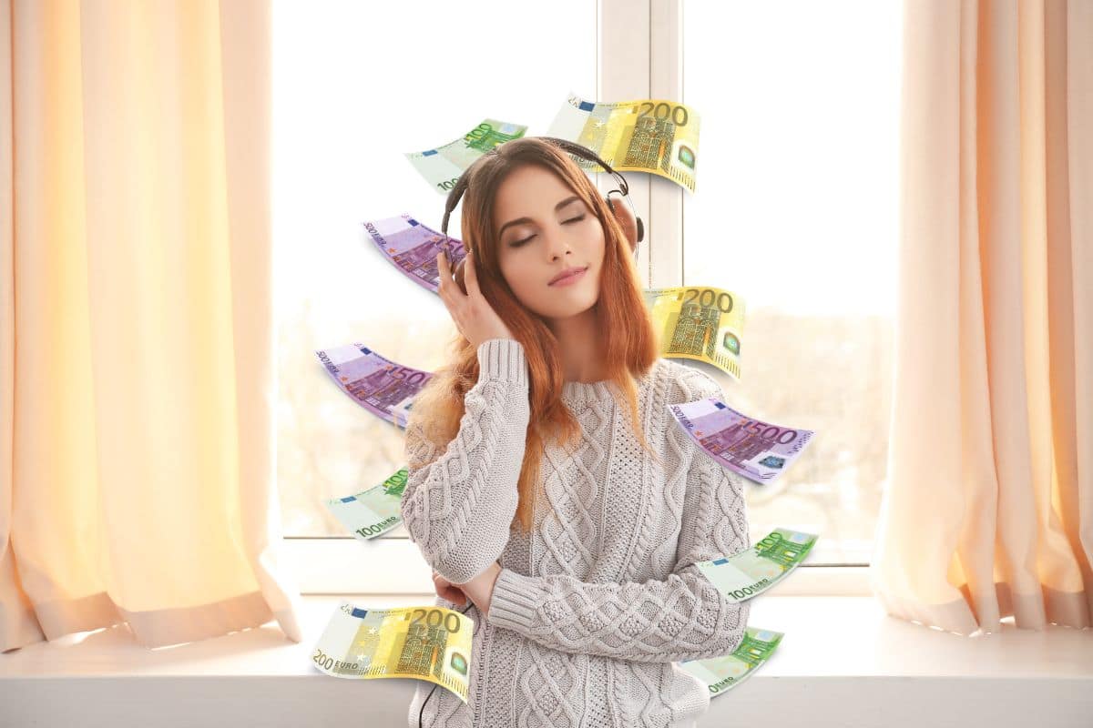 donna che ascolta musica in casa con le cuffie e banconote euro
